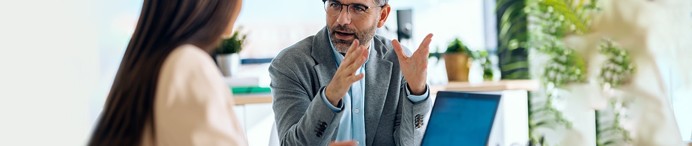 Assessor explaining a point to a colleague at a laptop