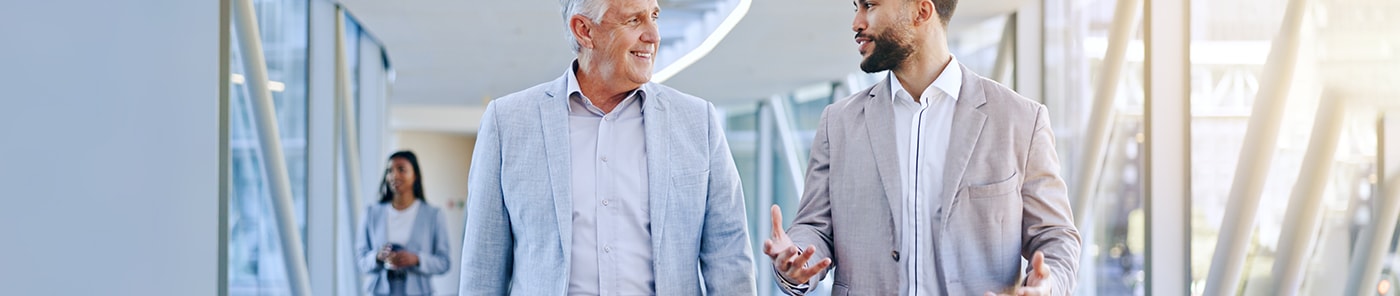 Two executives talking as they walk through an office
