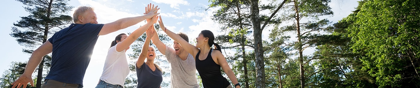 Team joining hands outdoors during a team-building activity