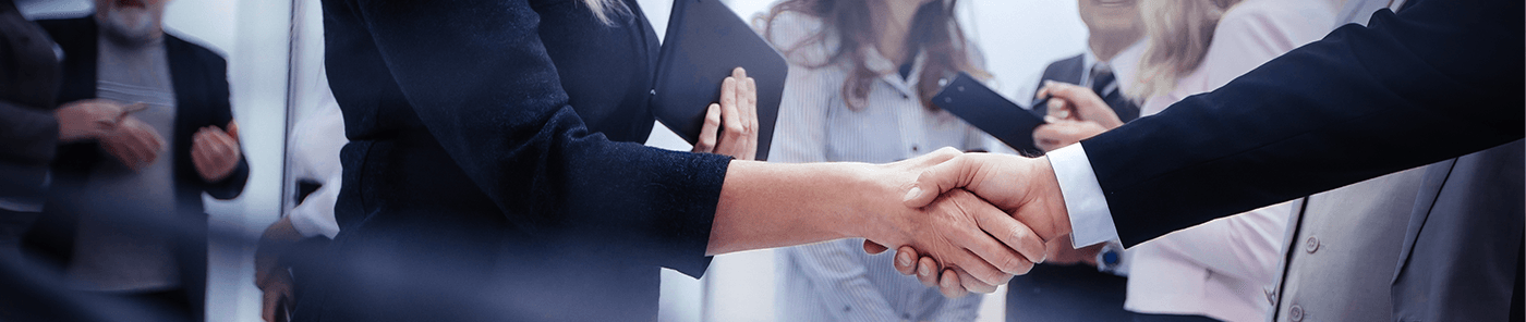 Professionals shaking hands in a busy office