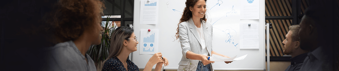 Facilitator presenting at a whiteboard to a seated group