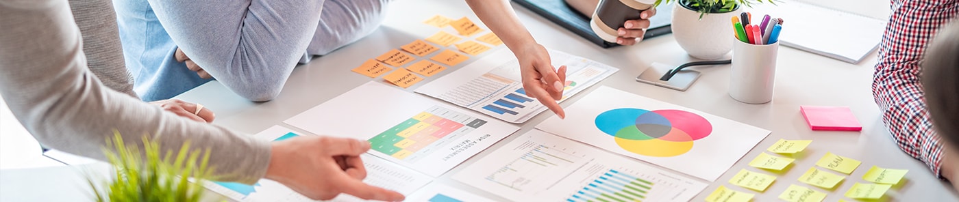 Colleagues reviewing charts together around a desk